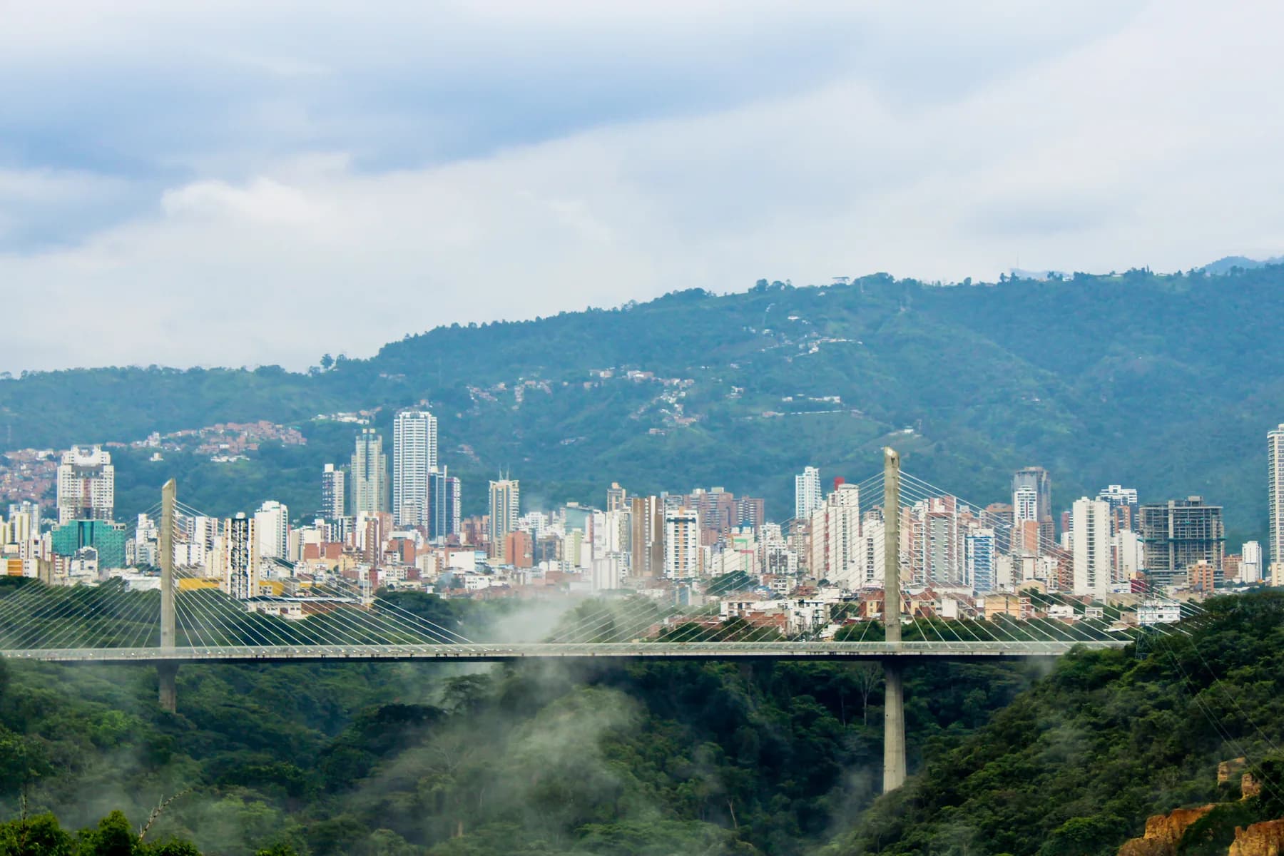 The Provincial Viaduct spans a green valley before the skyline and mountains of Bucaramanga, Colombia.