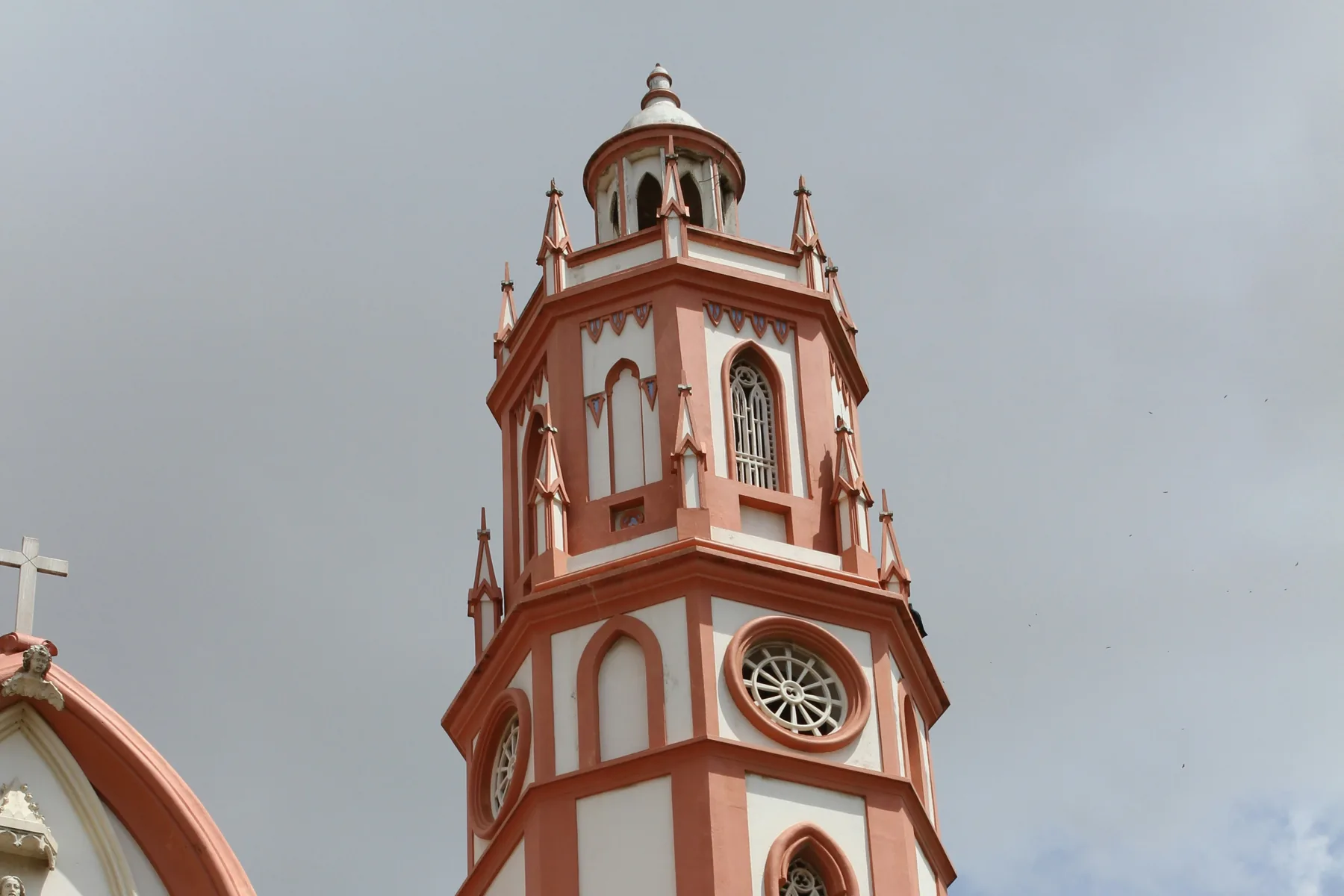 Detail of the pink and white upper bell tower of Iglesia San Nicolás de Tolentino in Barranquilla, Colombia.