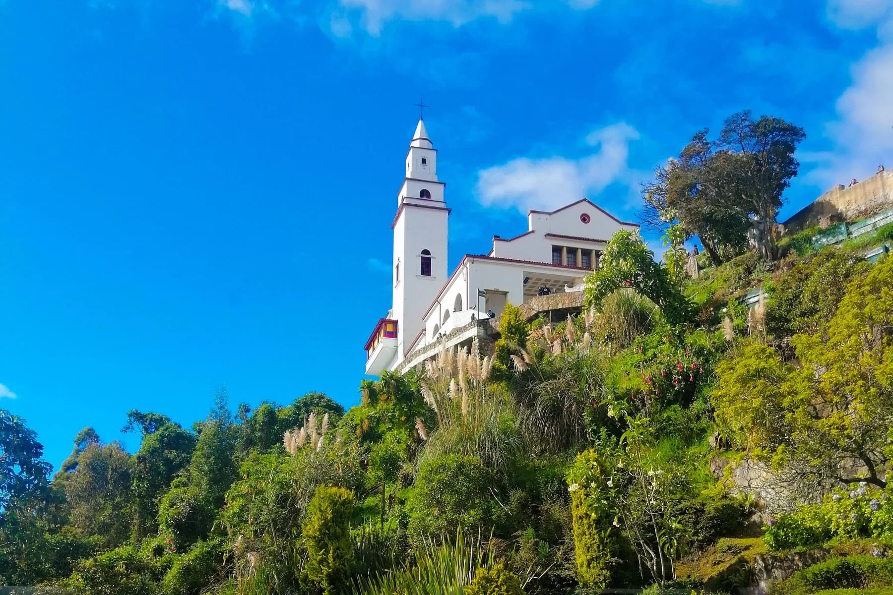 The white tower of Monserrate Sanctuary above terraced gardens in Bogotá, Colombia.