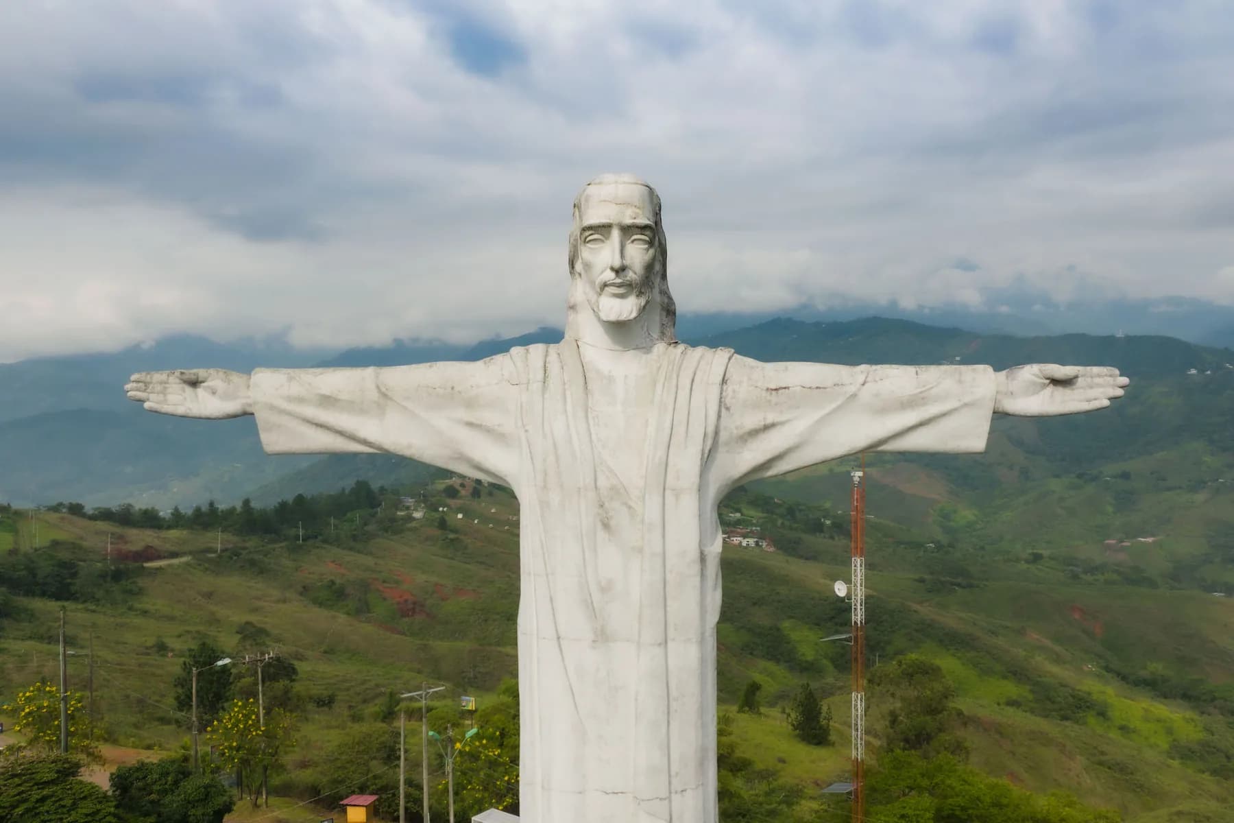 Cristo Rey with outstretched arms above the green hills of Cali, Colombia.