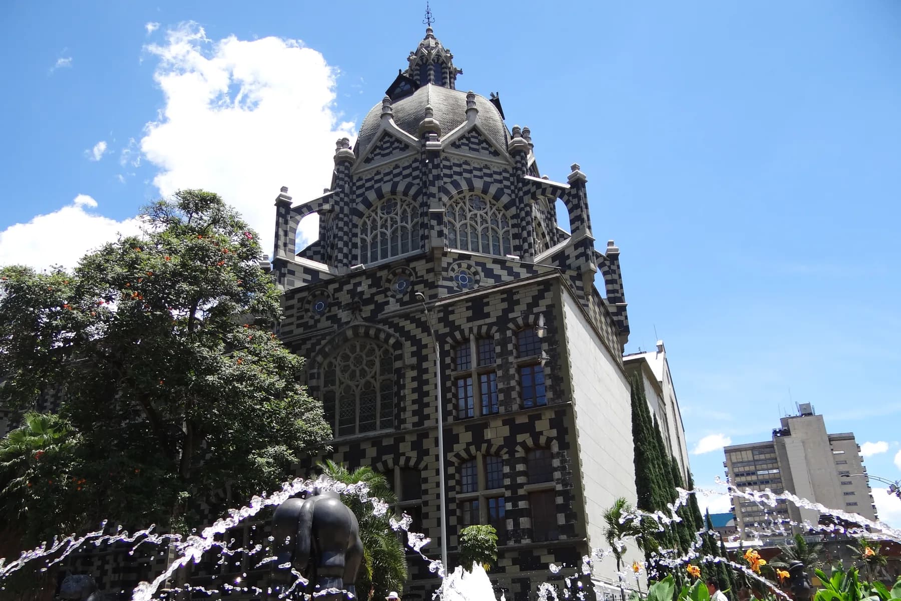 The dome of Palacio de la Cultura Rafael Uribe Uribe above a plaza fountain in Medellín, Colombia.