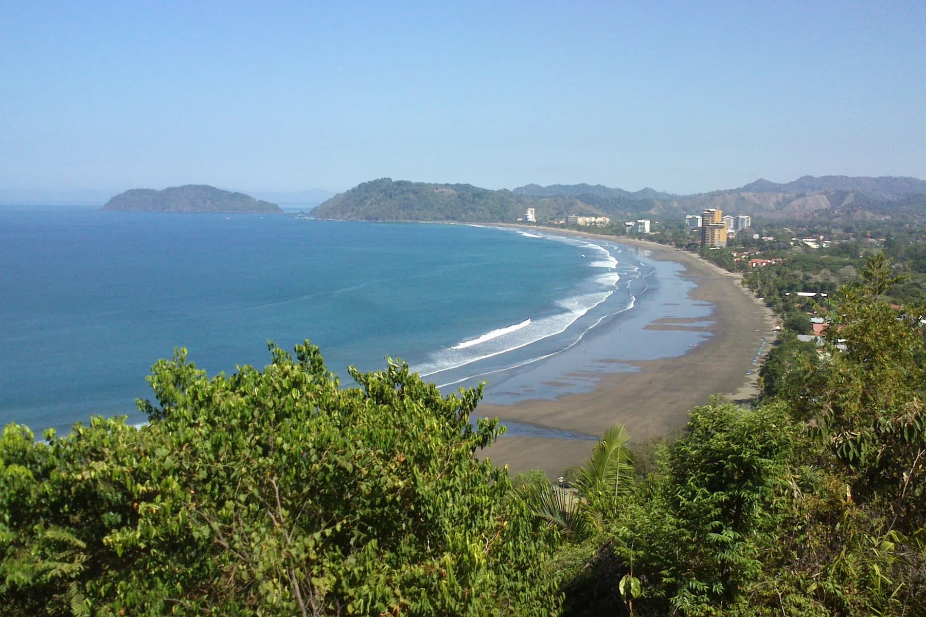 A sweeping view of Jacó Beach and the coastal town from the surrounding hills.