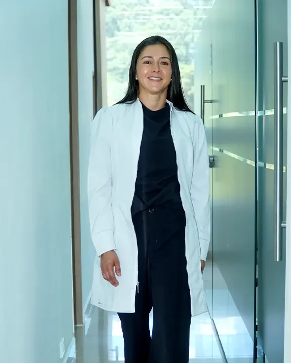 Ana Zuluaga in a white coat inside her dental clinic