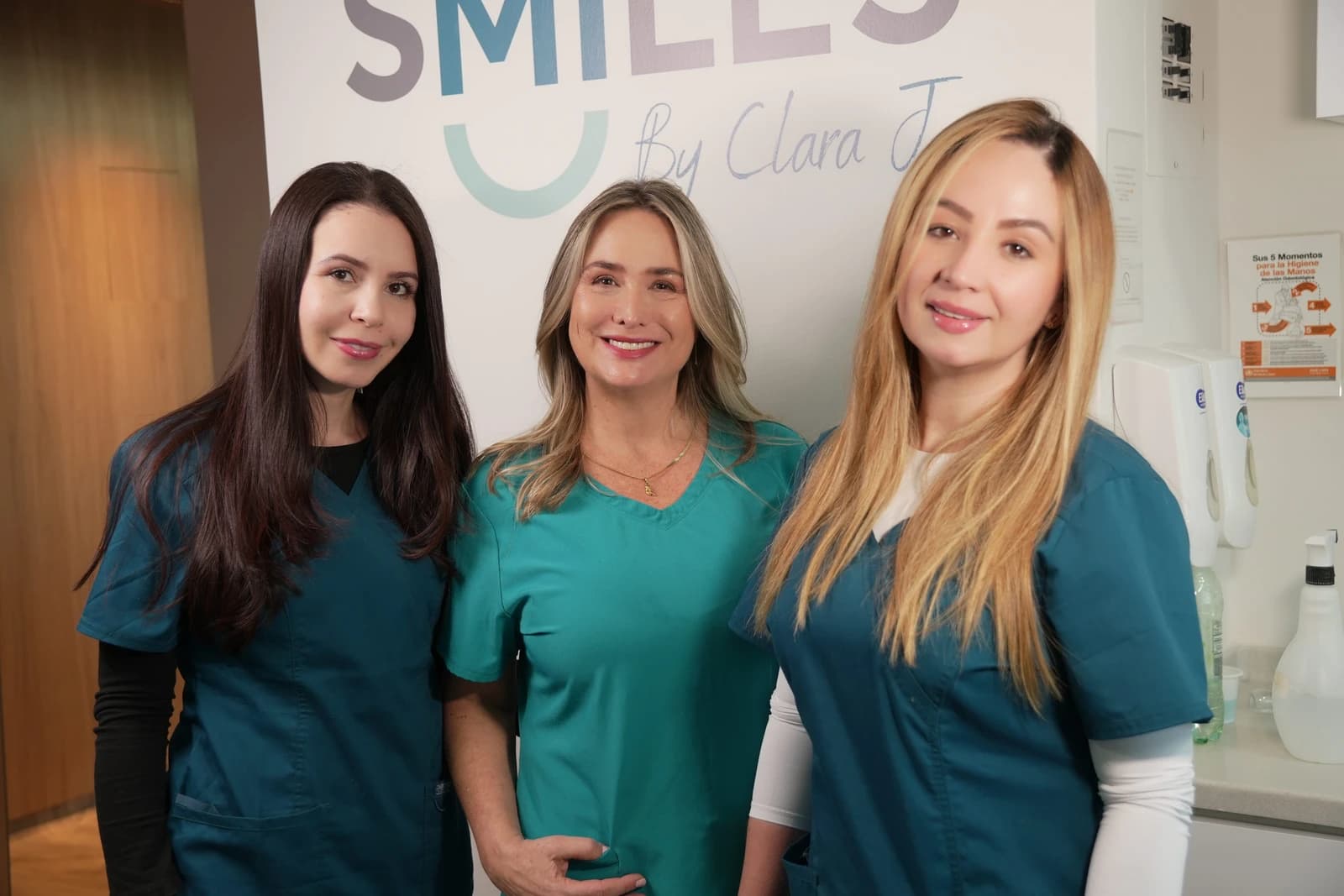 Three clinic team members in teal clinical clothing at Smiles by Clara