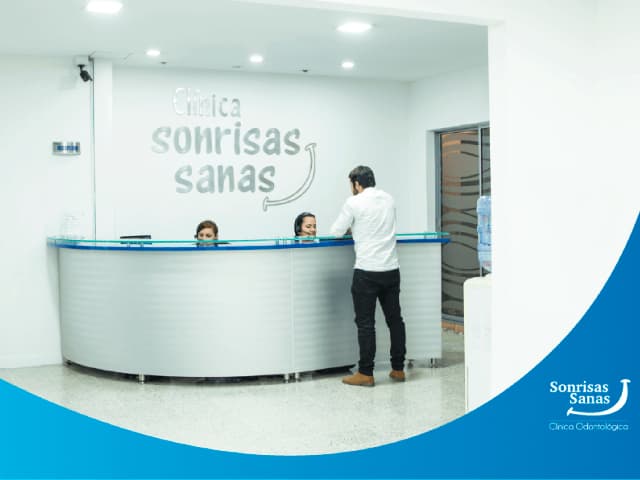 Clínica Sonrisas Sanas reception with clinic name on the wall
